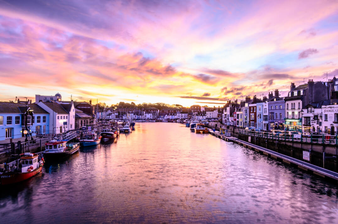 Weymouth harbour at sunrise with a colourful sky