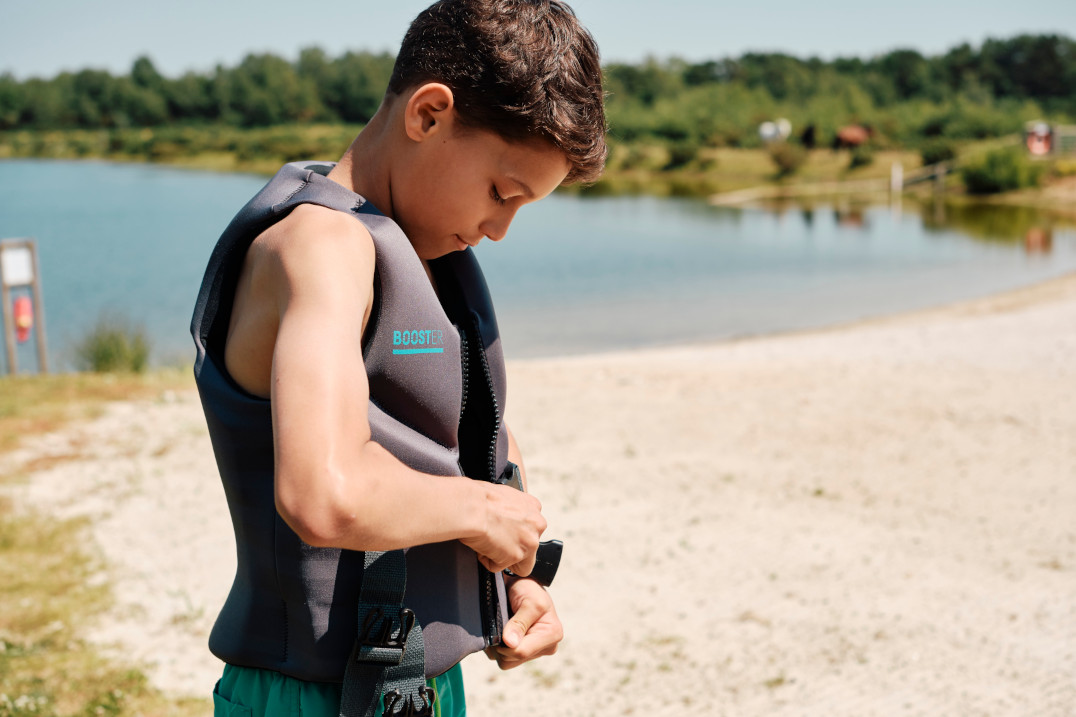 A boy doing up his lifejacket