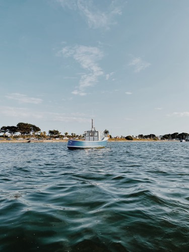 A boat on the water by Sandbanks beach