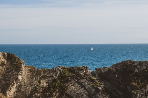 A sailing yacht in the distance off the coast of Dorset