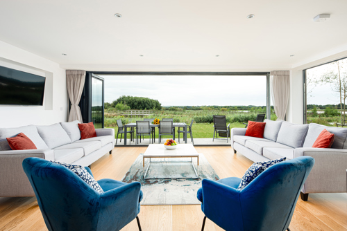 reception room with sofas looking out through large open doors