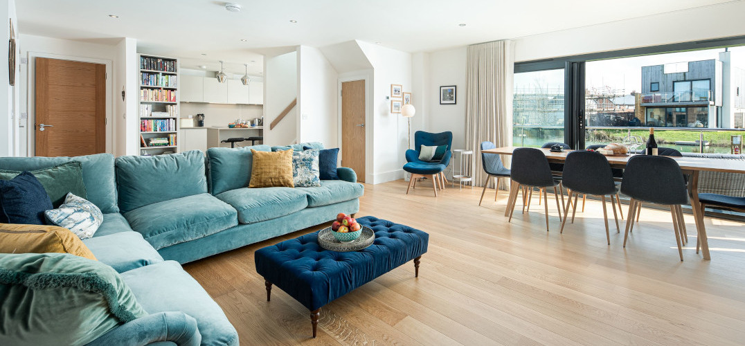 Open plan lounge and dining area with blue sofa and coffee table