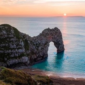 Durdle Door with the sun setting in the background